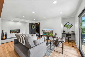 Living room featuring a tile fireplace and light hardwood / wood-style flooring