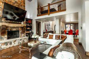 Living room featuring a high ceiling, a fireplace, and hardwood / wood-style flooring