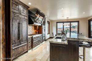 Kitchen featuring a breakfast bar area, dark brown cabinets, a kitchen island, decorative light fixtures, and sink