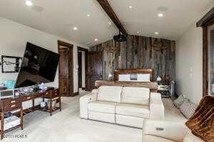 Bedroom featuring light colored carpet and wooden walls