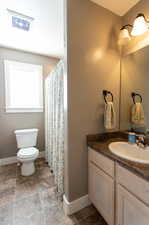 Bathroom with vanity, tile patterned floors, and toilet