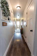 Hall featuring dark hardwood / wood-style flooring and a textured ceiling