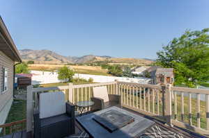 Wooden deck with a mountain view and a yard