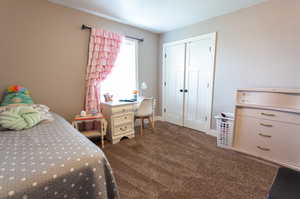 Bedroom featuring a closet and dark carpet