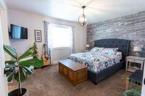 Bedroom featuring a notable chandelier and carpet floors