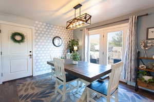 Dining room with dark wood-type flooring and a chandelier