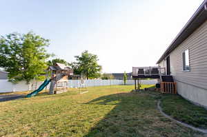 View of yard with a playground and a deck