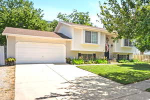 View of front facade featuring a garage and a front yard