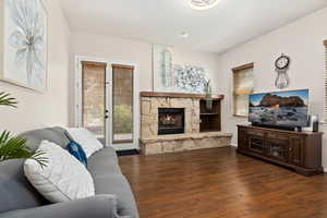 Living room with dark hardwood / wood-style flooring and a fireplace