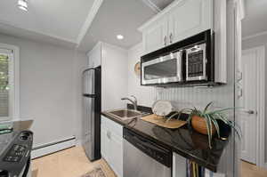 Kitchen featuring stainless steel appliances, a breakfast bar, white cabinetry, and granite countertops