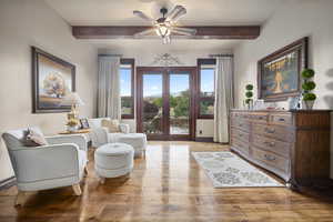 Living room with beamed ceiling, french doors, ceiling fan, and light hardwood / wood-style floors