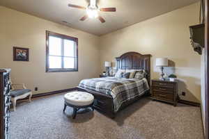 Carpeted bedroom featuring ceiling fan