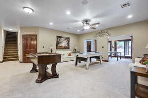 Recreation room with light carpet, a textured ceiling, and ceiling fan