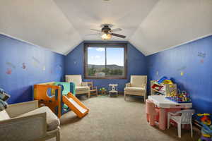 Recreation room featuring carpet floors, a textured ceiling, ceiling fan, and vaulted ceiling