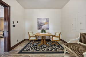 Dining area with electric panel and hardwood / wood-style floors