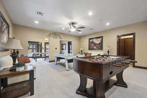 Recreation room with light carpet and ceiling fan