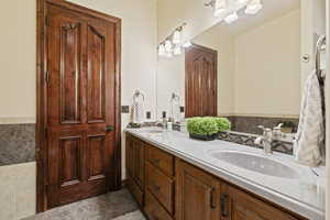 Bathroom with tile patterned flooring and dual vanity