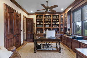 Office space with crown molding, light wood-type flooring, and ceiling fan