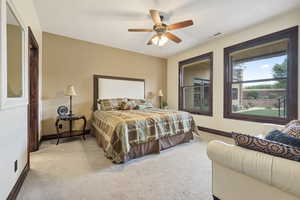 Carpeted bedroom featuring ceiling fan