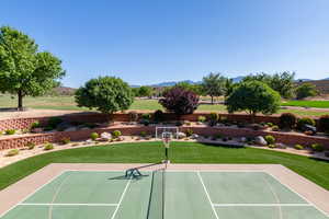 View of tennis court featuring a mountain view, basketball court, and a lawn