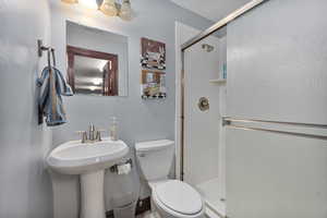 Bathroom with a shower with shower door and toilet