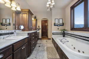 Bathroom with tile patterned floors, double vanity, and a chandelier