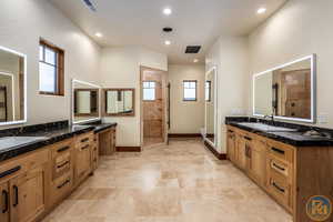 Bathroom with dual bowl vanity, toilet, and tile patterned floors