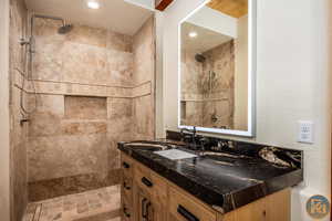 Bathroom with tiled shower and vanity