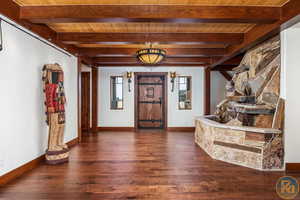 Foyer featuring beamed ceiling, wooden ceiling, and dark wood-type flooring