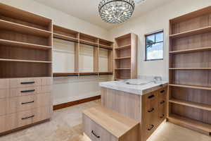 Spacious closet with travertine tile floors