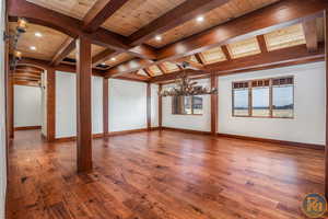 Interior space featuring beamed ceiling, wood-type flooring, wood ceiling, and an inviting chandelier