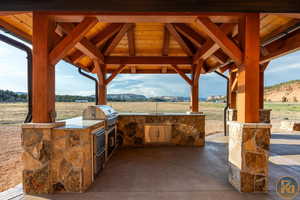 View of outdoor kitchen featuring a mountain view, area for grilling, a gazebo, and a grill