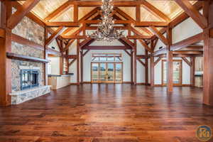 Unfurnished living room featuring beamed ceiling, wood ceiling, and hardwood / wood-style floors