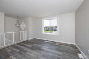 Spare room with dark hardwood / wood-style flooring and a textured ceiling