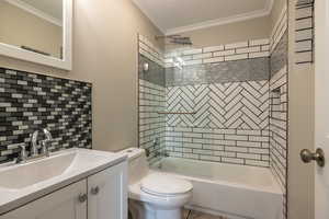 Full bathroom featuring backsplash, toilet, tiled shower / bath combo