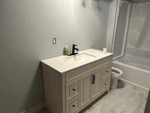 Full bathroom with tile patterned flooring, toilet, vanity, and shower / bathtub combination