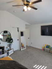 Carpeted bedroom featuring lofted ceiling and ceiling fan, and  walk in closet.