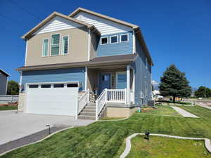 View of front of this two story home featuring a garage, central AC, a front lawn, and covered porch