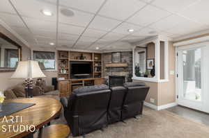 Lower Level Living room with built in shelves, ornamental molding, a fireplace, and hardwood / wood-style flooring