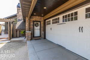 View of exterior entry with a garage