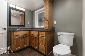 Bathroom featuring hardwood / wood-style floors, toilet, and vanity