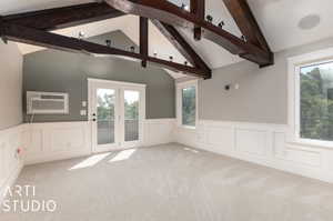 Primary bedroom with lofted ceiling with beams and a wall mounted air conditioner