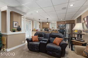 Lower Level living room featuring carpet floors, crown molding, and a drop ceiling