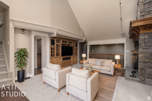 Living room featuring high vaulted ceiling and light hardwood / wood-style flooring