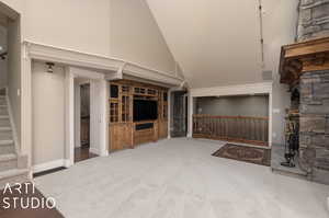 Living room featuring carpet flooring and high vaulted ceiling