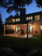 Rear view of house with a lawn and a patio area