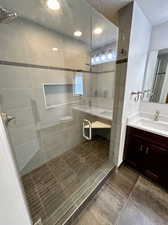 Bathroom featuring a shower with door, vanity, tile patterned flooring, and a textured ceiling