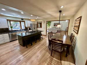 Dining area featuring an inviting chandelier, sink, and light wood-type flooring