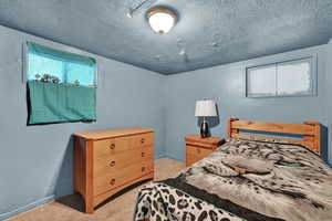 Carpeted bedroom featuring a textured ceiling