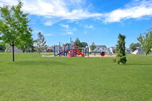 View of jungle gym with a lawn